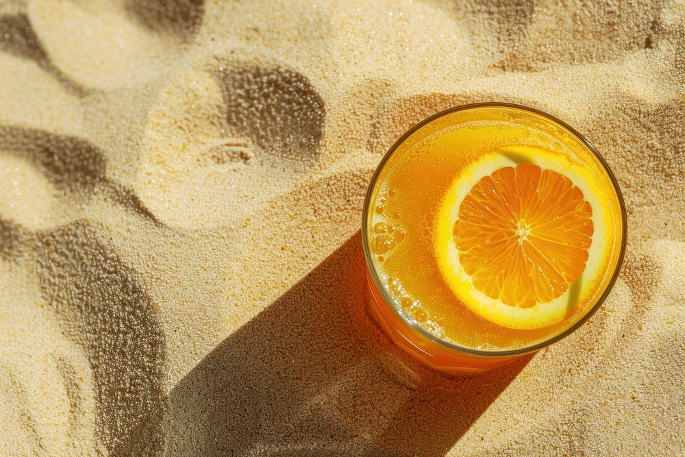 Orange juice on sand outdoors fruit drink.