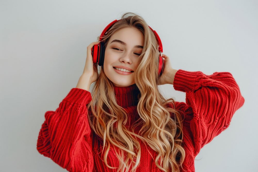 Young woman blond long hair enjoying happy and cheerful using headphone sweater headphones listening.
