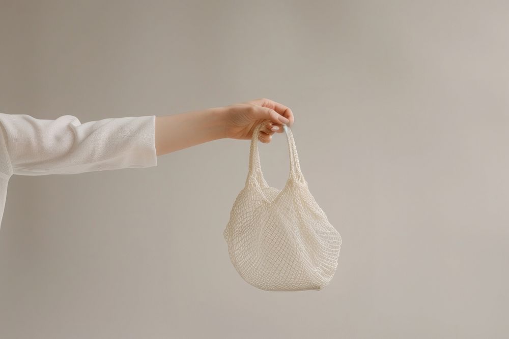 Hand holding net bag handbag adult accessories.
