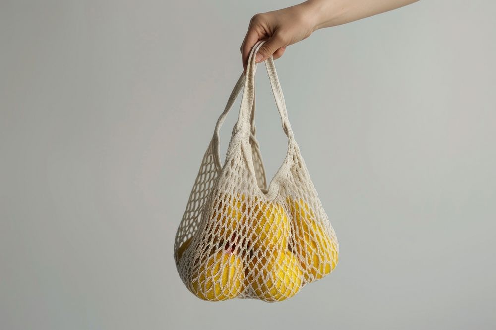 Hand holding net bag handbag fruit accessories.