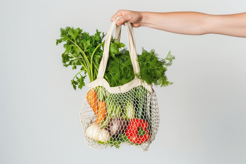Hand holding net shopping bag vegetable cauliflower ingredient.
