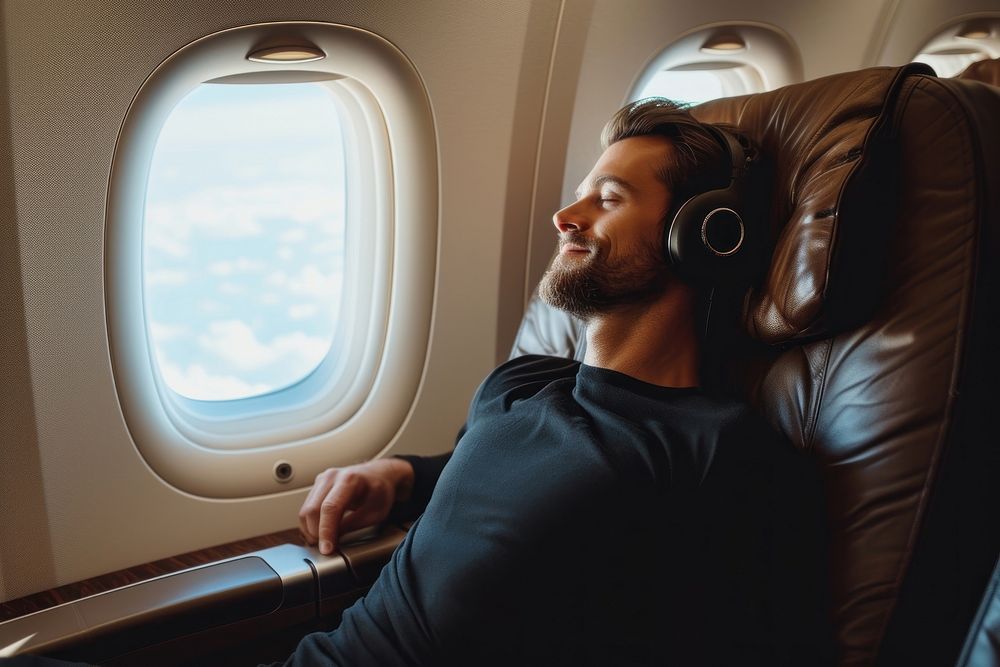Happy man passenger sitting on business class headphones headset window.