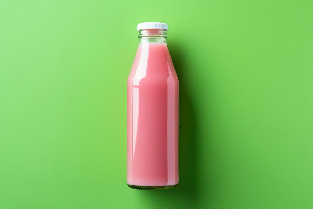 Bottle of pink cold pressed juice drink green milk.