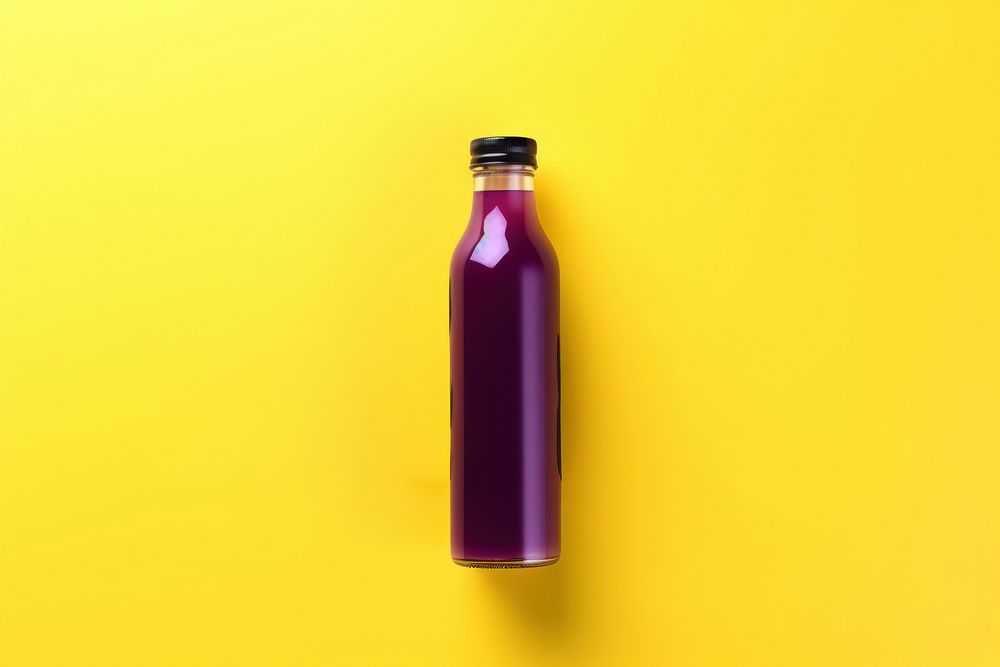 Bottle of purple berry cold pressed juice yellow refreshment container.