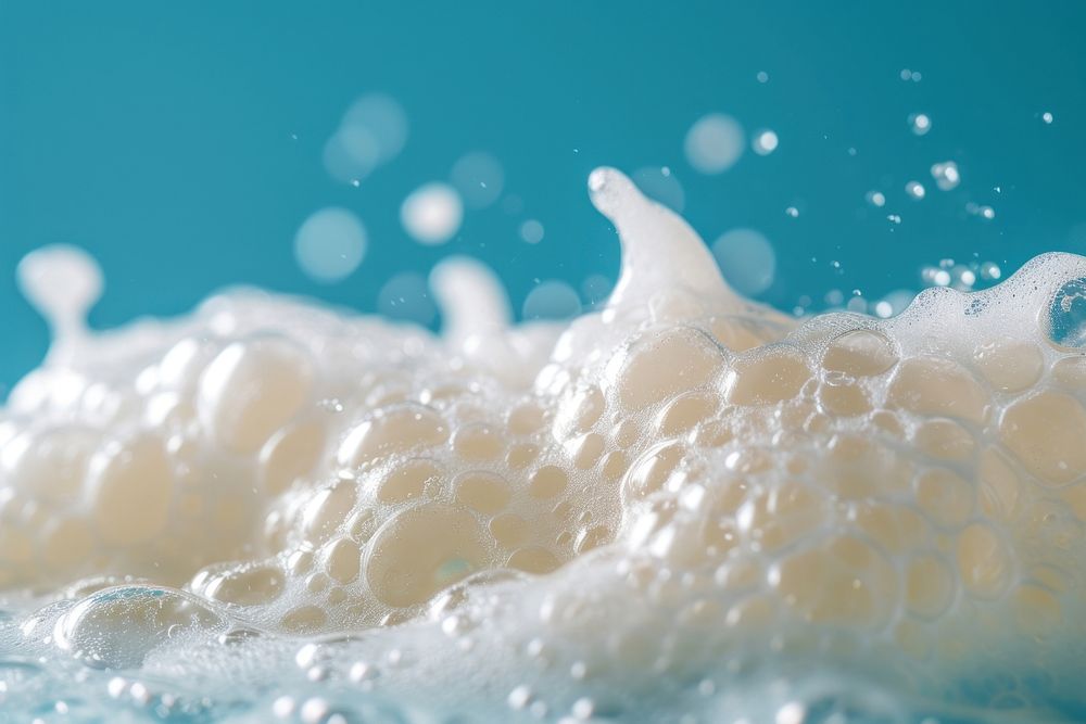 Textured bubbling foam on blue background milk underwater medication.