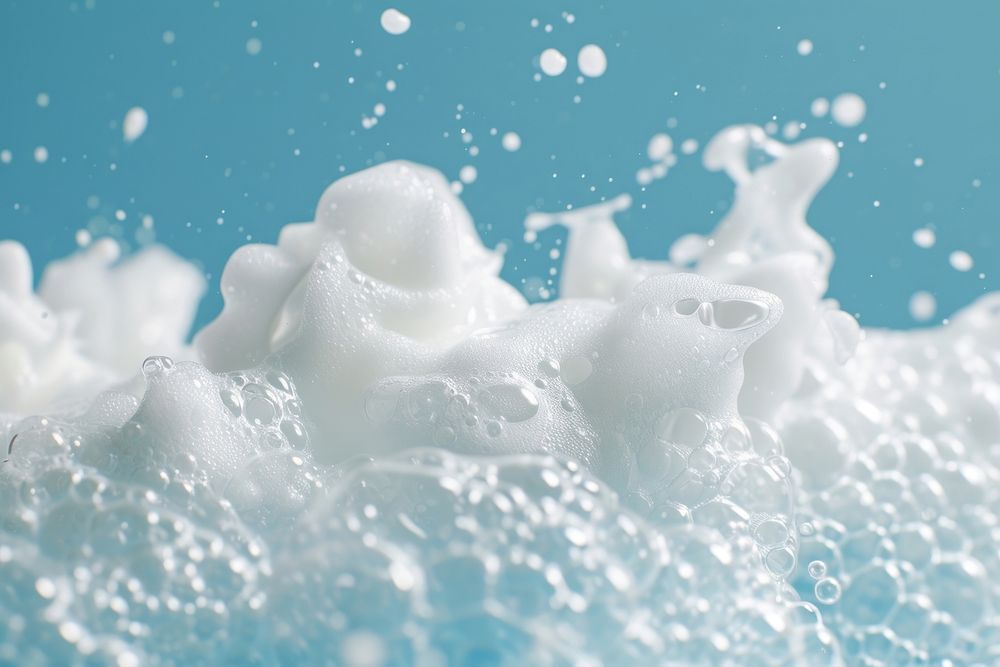 Textured bubbling foam on blue background milk snow splashing.