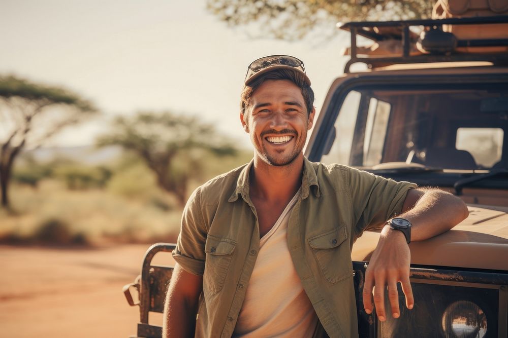 Man with safari vehicle smile standing outdoors.