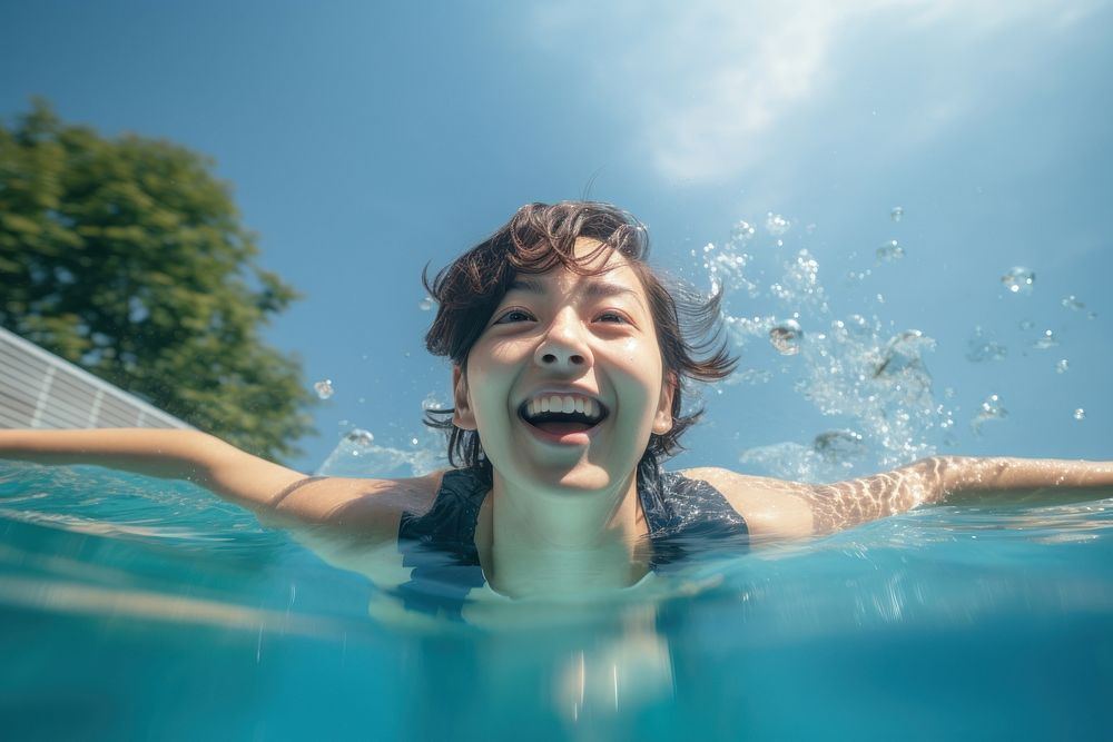 Aisan female swimming in a pool recreation outdoors smiling.