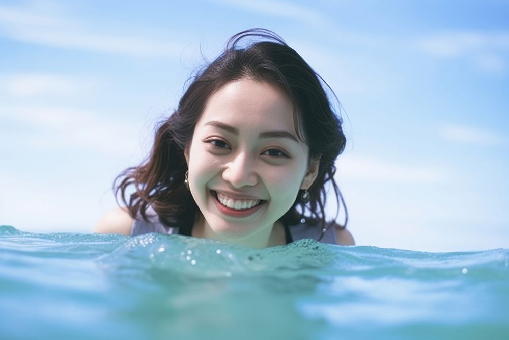 Aisan female swimming in a pool smiling sports summer.