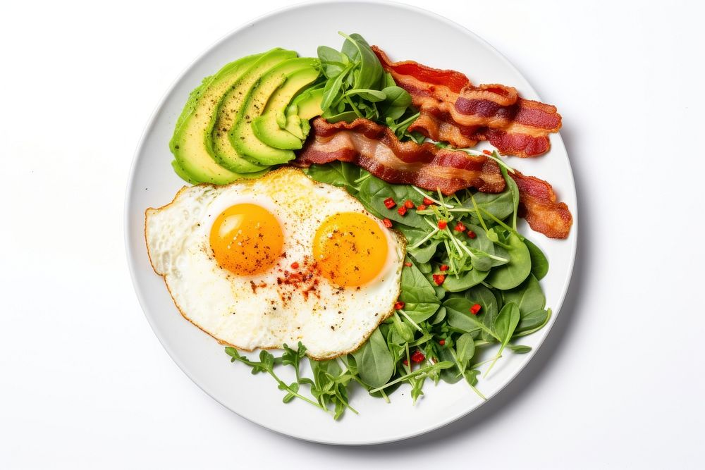 Keto friendly low carb breakfast plate with sunny side up eggs spinach avocado bacon.