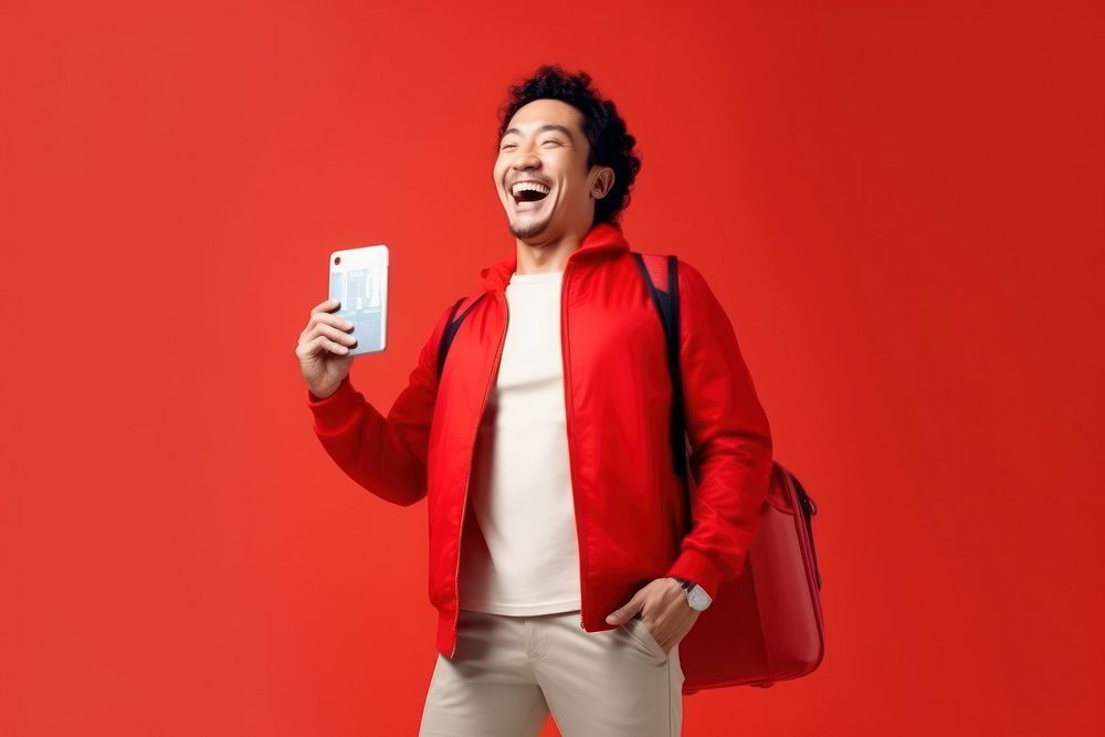Happy Asian tourist with flight ticket laughing adult red.