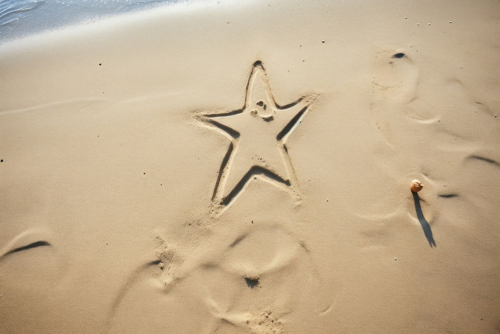 Star shape doodle finger-drawing outdoors nature beach.