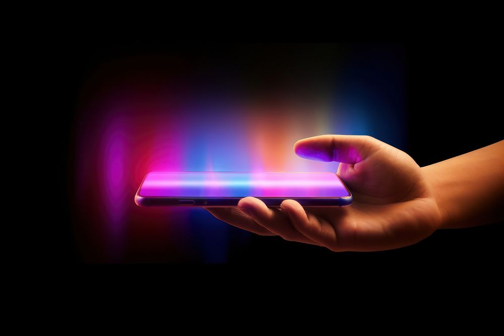 Hand holding phone light purple illuminated.