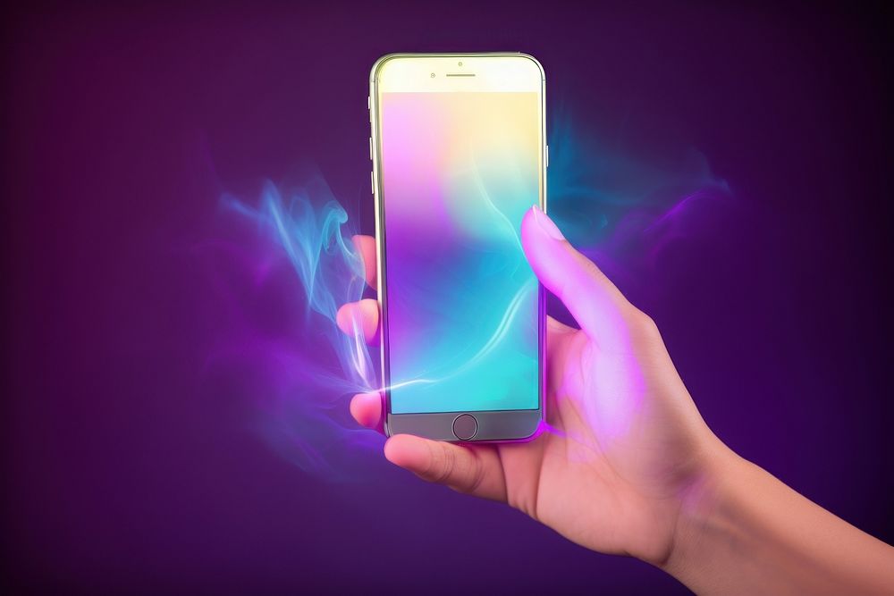 Hand holding phone light illuminated electronics.