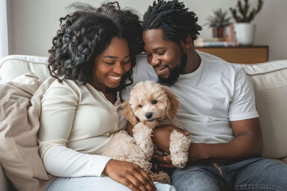 A happy black family on a sofa and a puppy in the living room romantic female person.