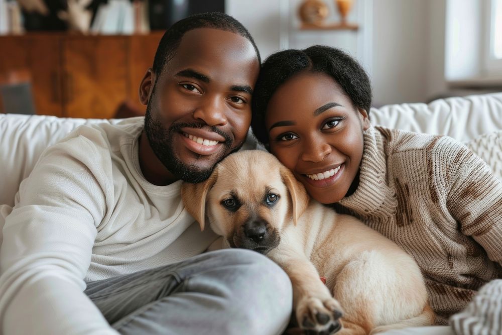 A happy black family on a sofa and a puppy in the living room photography portrait romantic.