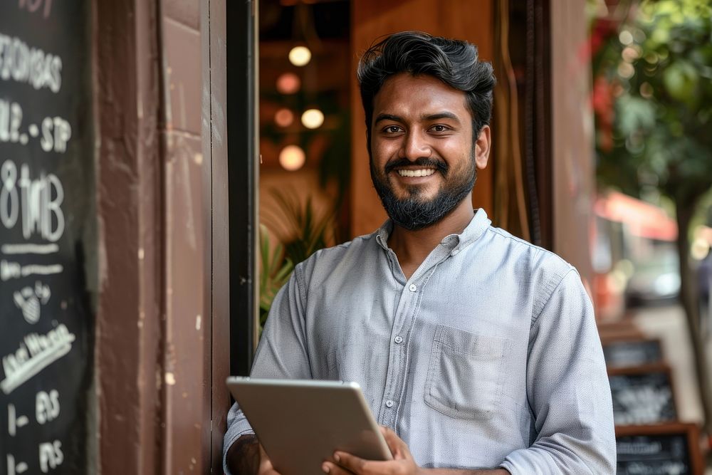 Indian man holding tablet electronics blackboard computer.