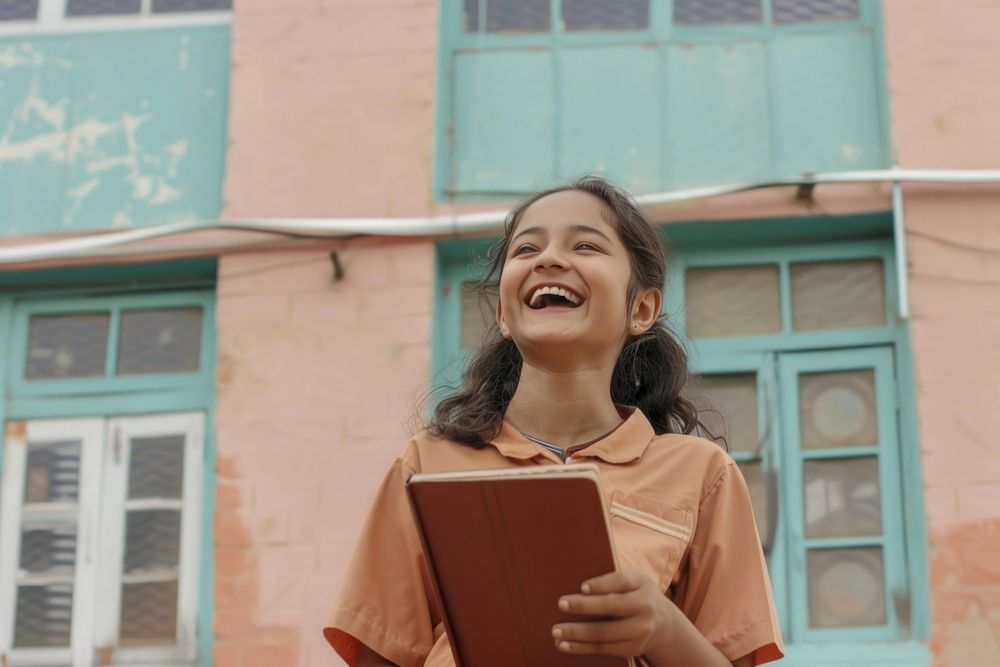 South Asian girl holding book laughing person female.