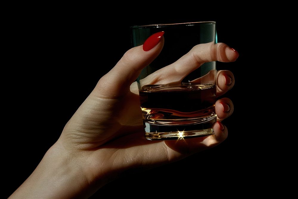 Woman hand with red nail hold a glass of whisky finger refreshment cosmetics.