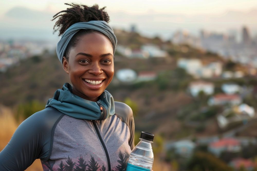 Happy african american female runner holding reusable water bottle portrait smile adult.