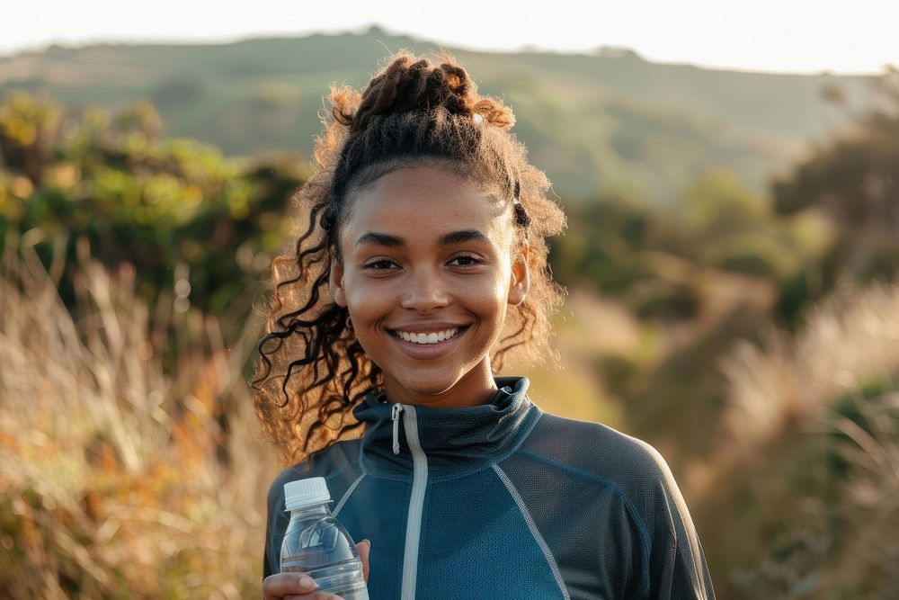 Happy african american female runner holding water bottle nature smile photo.