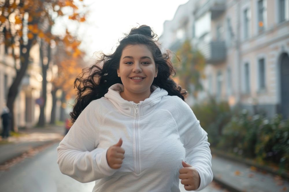 Happy chubby woman jogging in city outdoors portrait street.