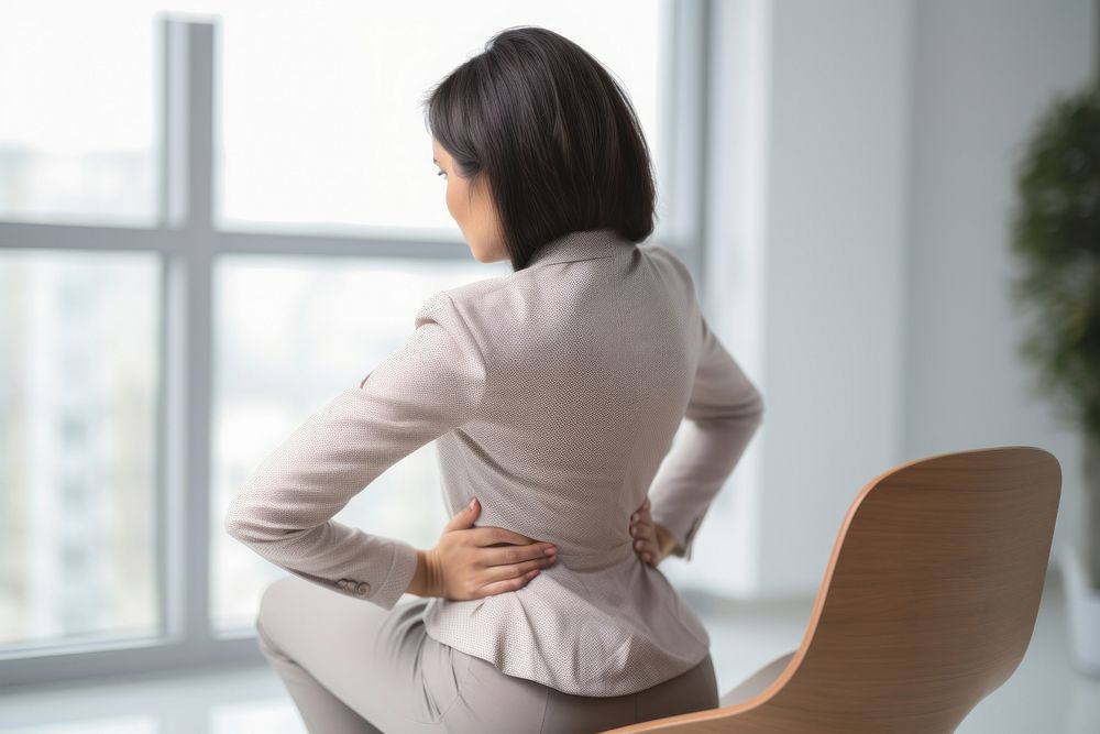 Woman sitting at chair with office syndrome back pain adult contemplation anticipation.