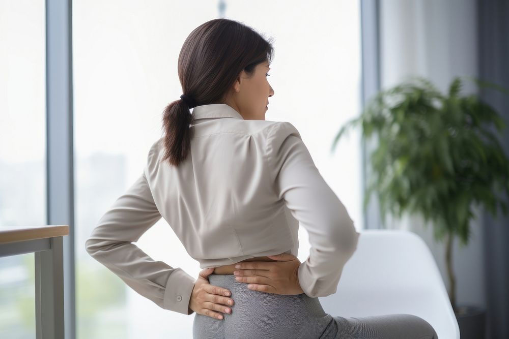 Woman sitting at chair with office syndrome back pain adult contemplation anticipation.