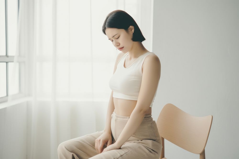 Woman sitting at chair with office syndrome back pain adult contemplation cross-legged.