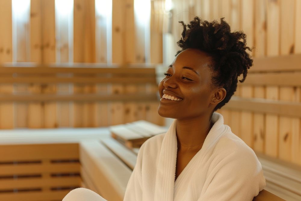 Happy young african american woman in white bathrobe sitting smile adult contemplation.