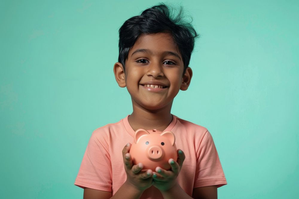 Indian kid holding a piggybank happy person female.