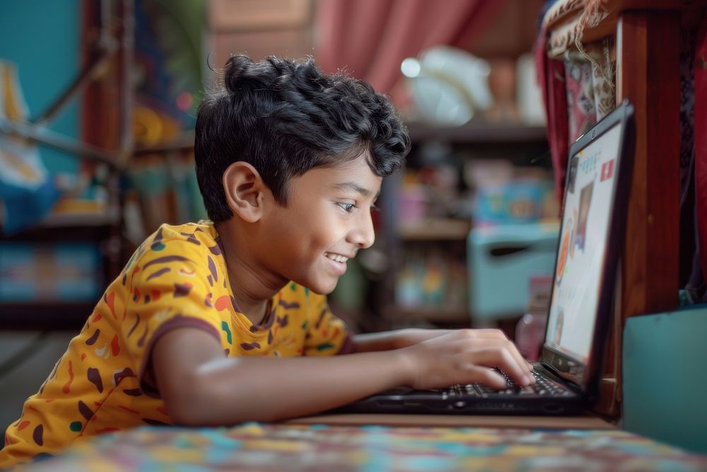 South Asian boy using laptop electronics computer hardware.