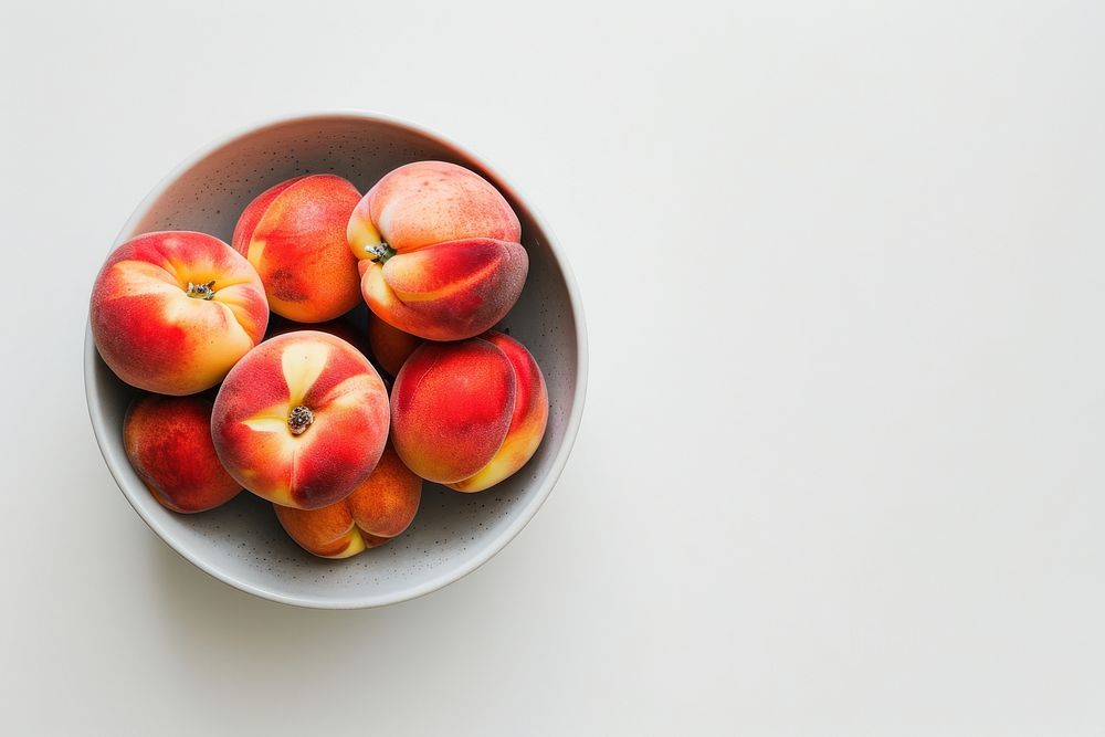 A bowl of peach produce fruit plant.