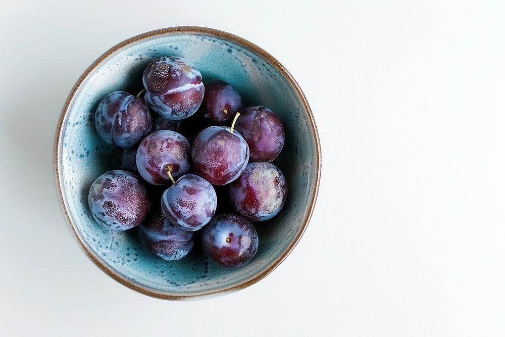 A bowl of plum produce fruit plant.