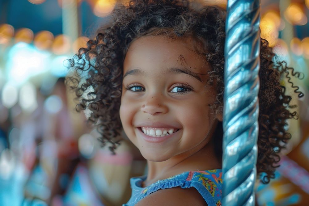 A mixed race child with curly hair smiles carousel photography portrait.