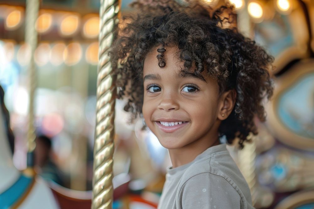 A mixed race child with curly hair smiles carousel photography portrait.