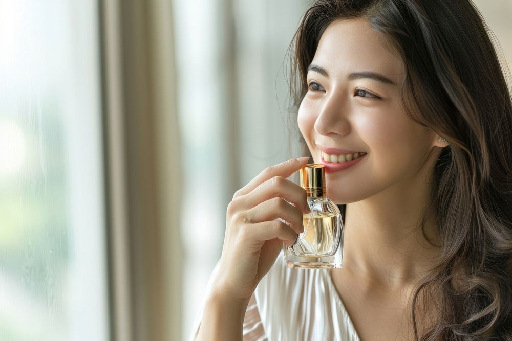 Woman smelling perfume cosmetics beverage drinking.