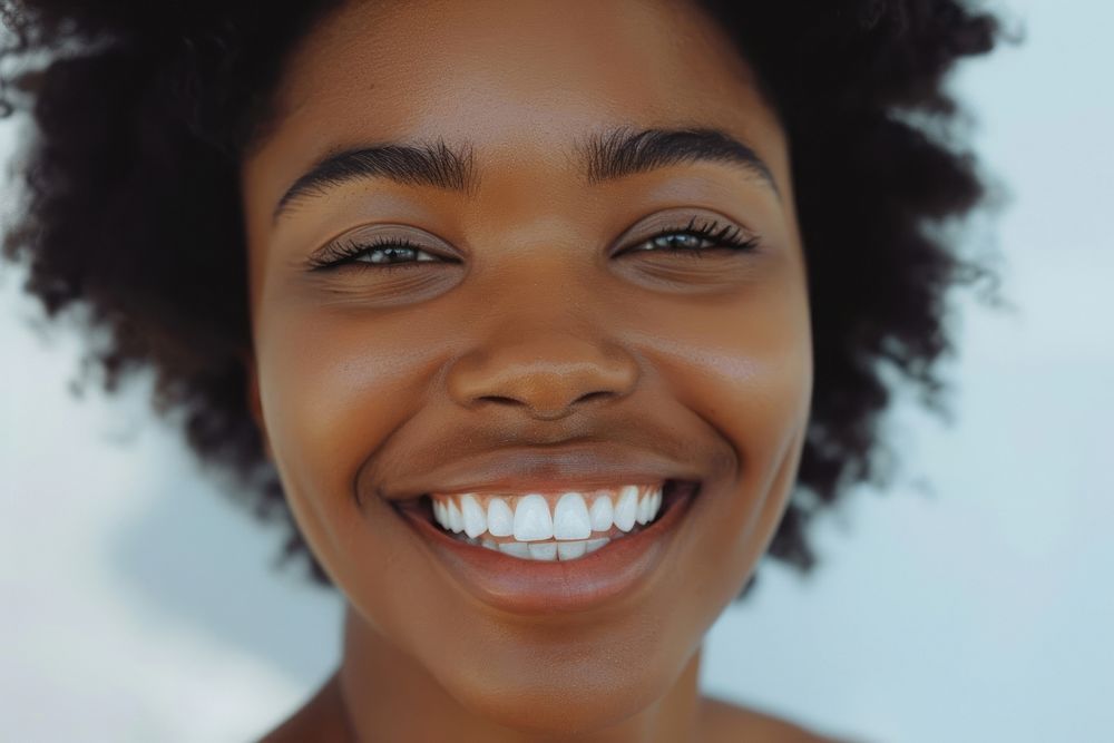 Beautiful black woman smiling with white teeth face skin laughing.