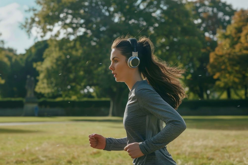 Woman running electronics headphones outdoors.