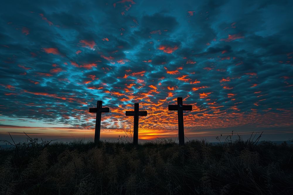 Three wooden crosses sky graveyard outdoors.