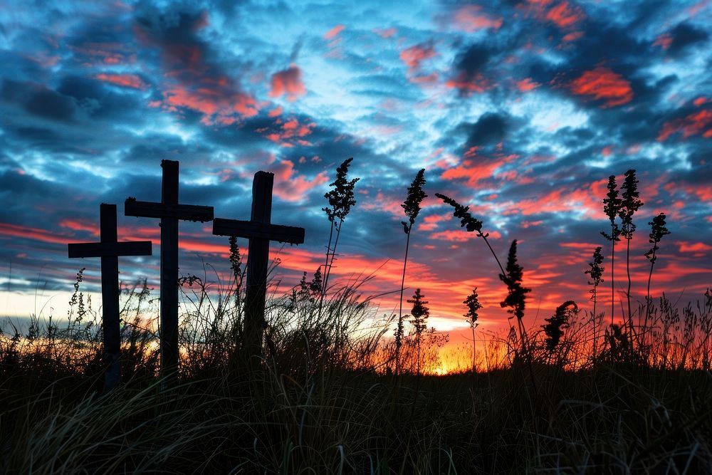 Three wooden crosses sunset sky graveyard.
