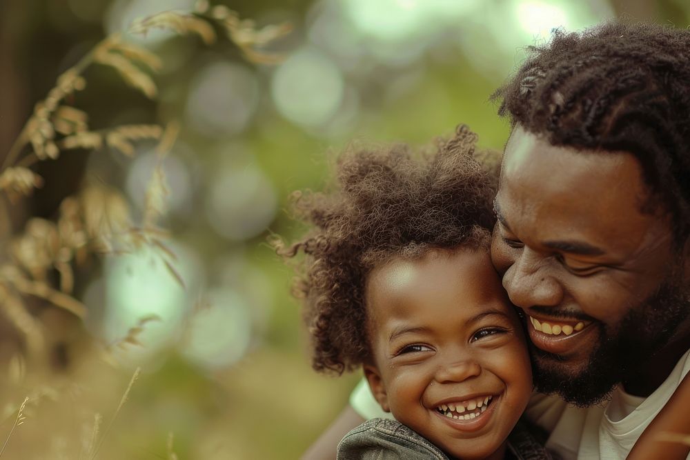 Black kid playing with father in the park laughing portrait family.