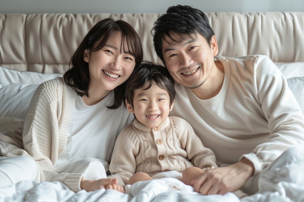 Happy asian family sit together adult baby bed.