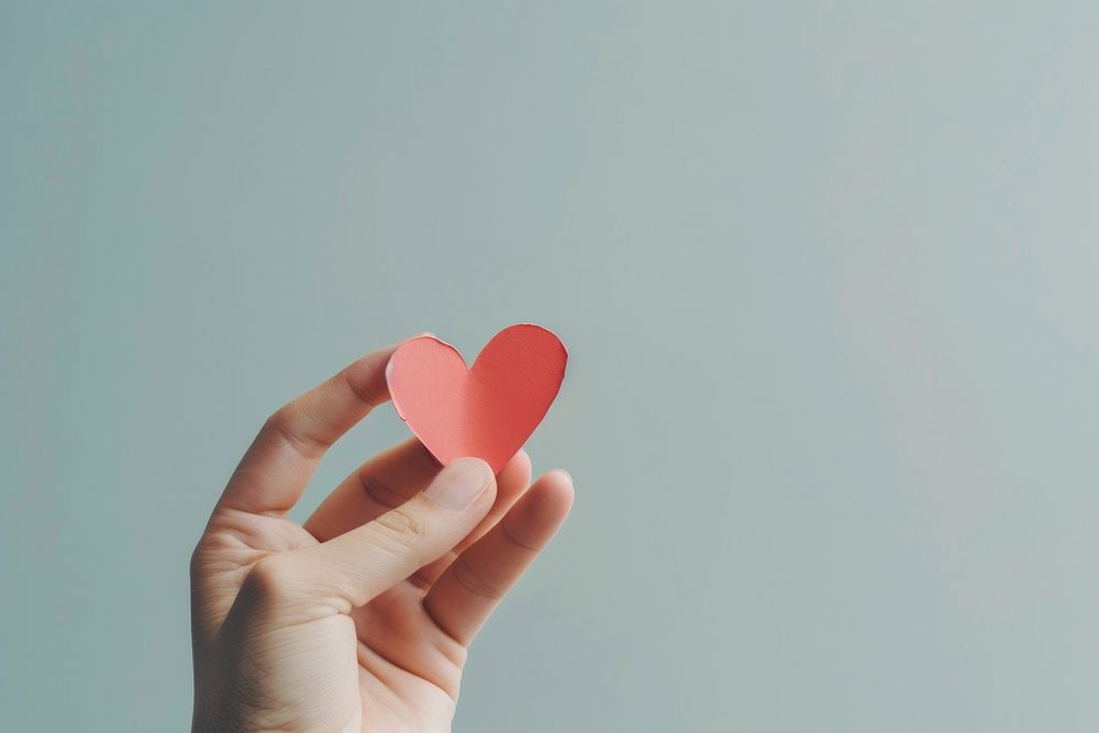 A heart shape paper cut model holding hand romance.