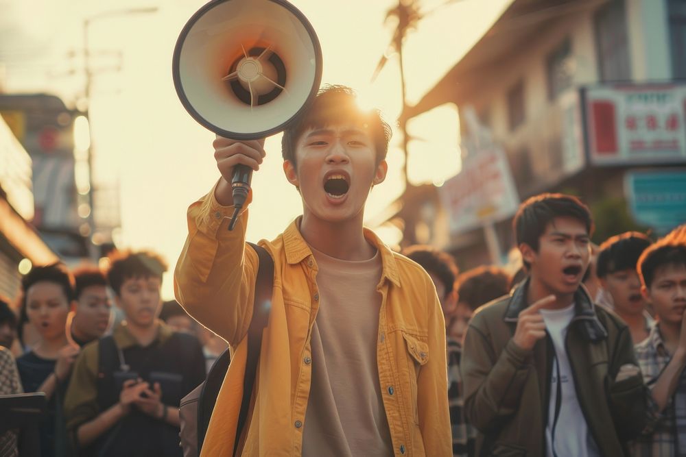 South east asian teenager using megaphone shouting person human.