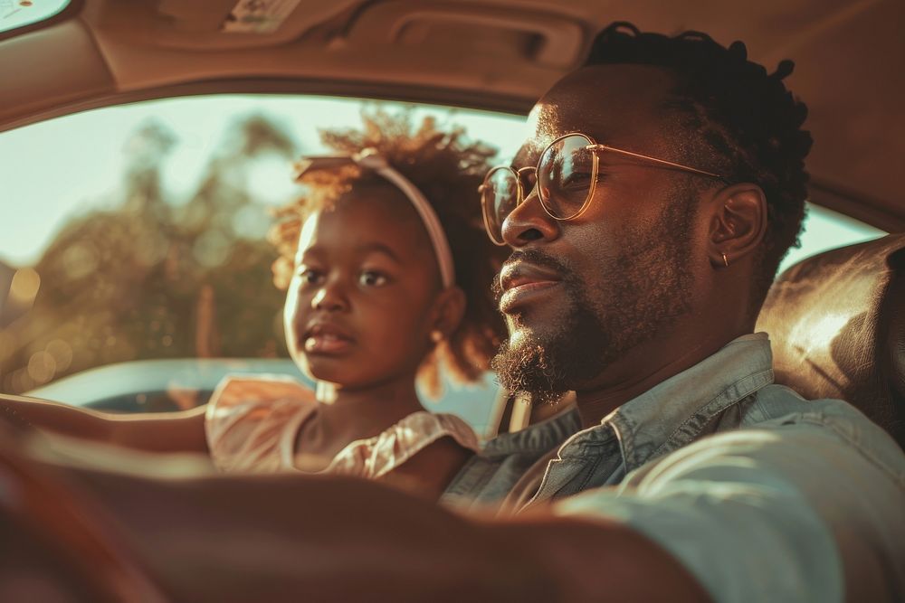 Black dad and daugther behind sitting in car together on the road trip transportation accessories accessory.