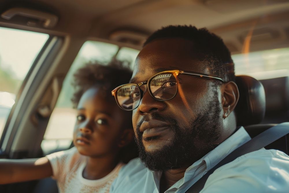Black dad and daugther behind sitting in car together on the road trip photo transportation accessories.