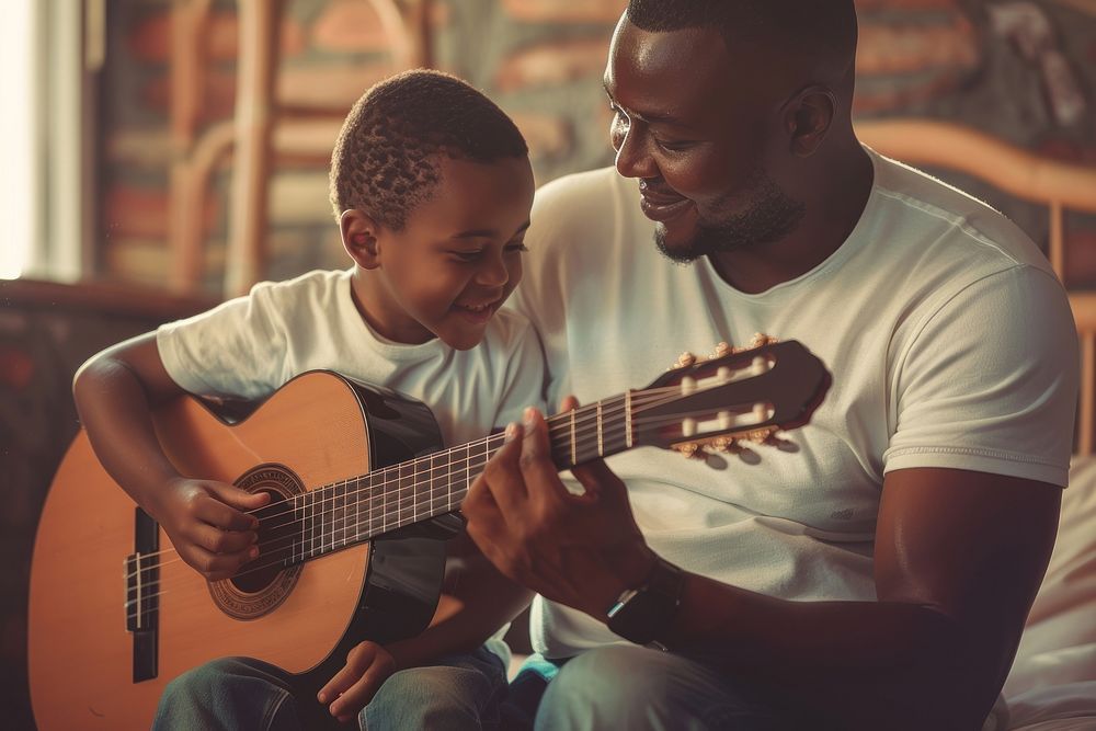 Black dad teaching son play guitar recreation guitarist performer.