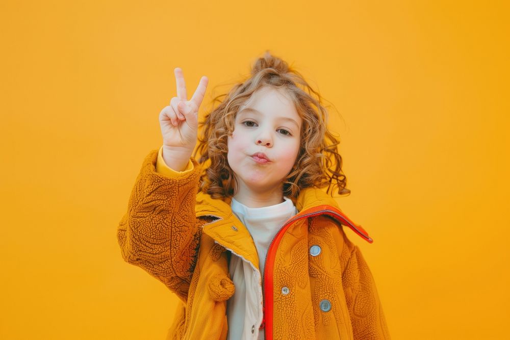 Photo of female kid with 2 finger pose portrait photography surprised.