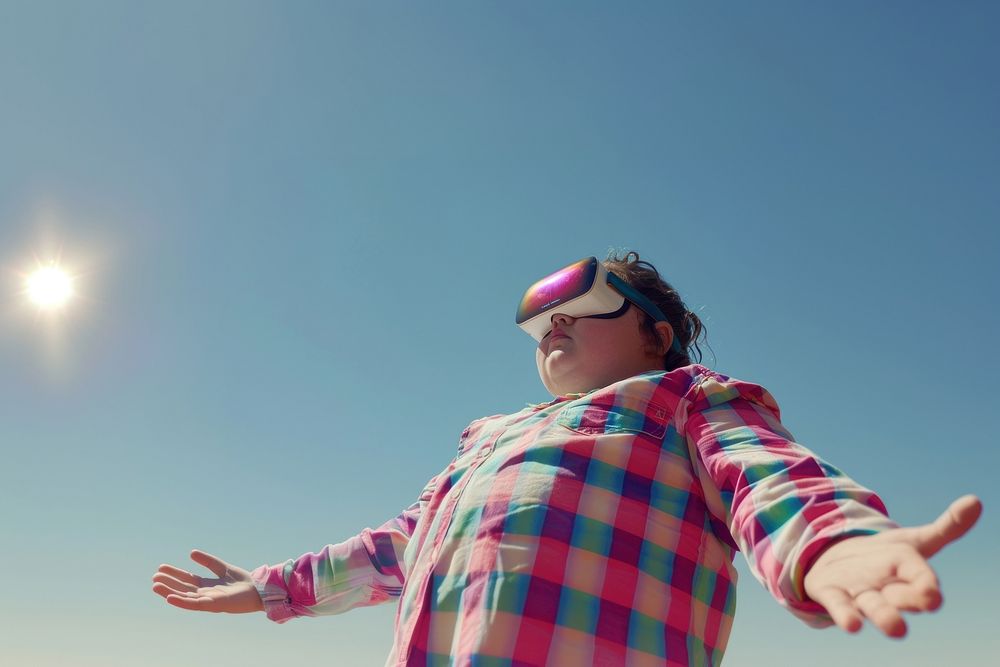Chubby kid wearing VR glasses sunglasses outdoors sky.